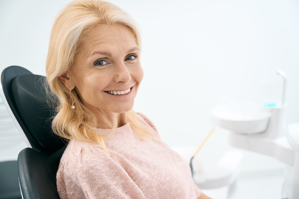 Señora sentada en el sillón dental esperando a que le instalen coronas dentales en Houston